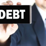 Людина в костюмі тримає смартфон зі словом «БОРГ» на екрані - ілюструє способи стягнення заборгованості